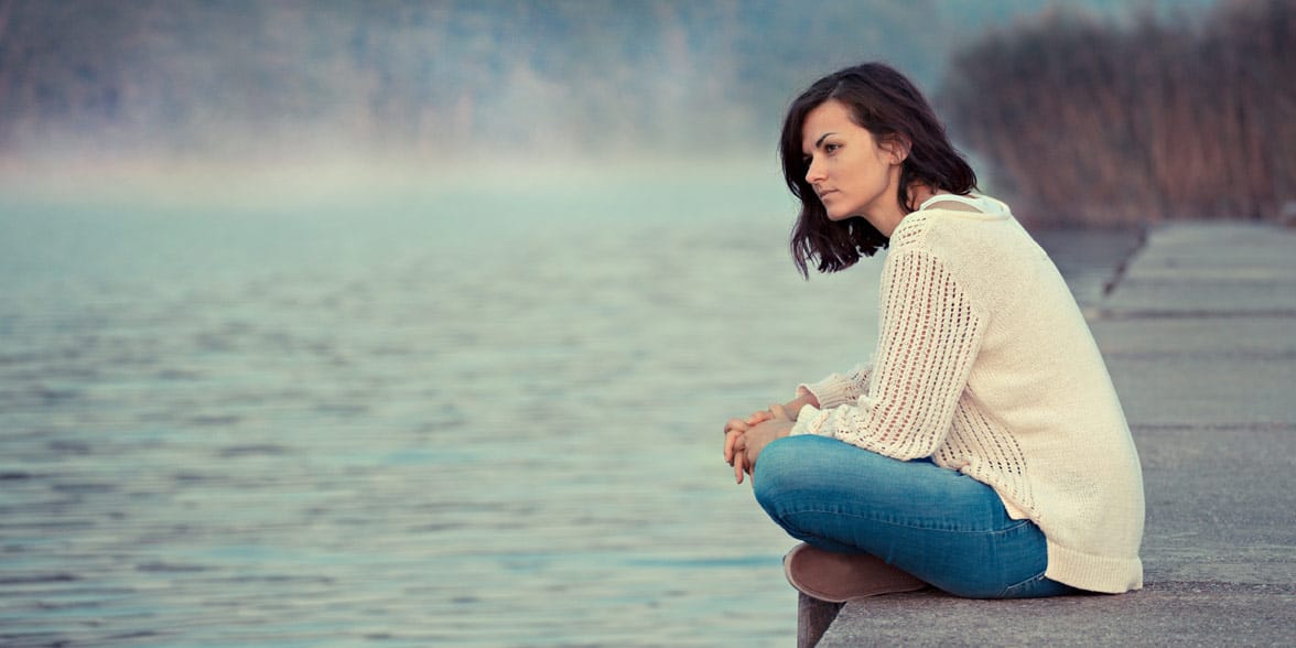 Photo of a woman on a dock thinking