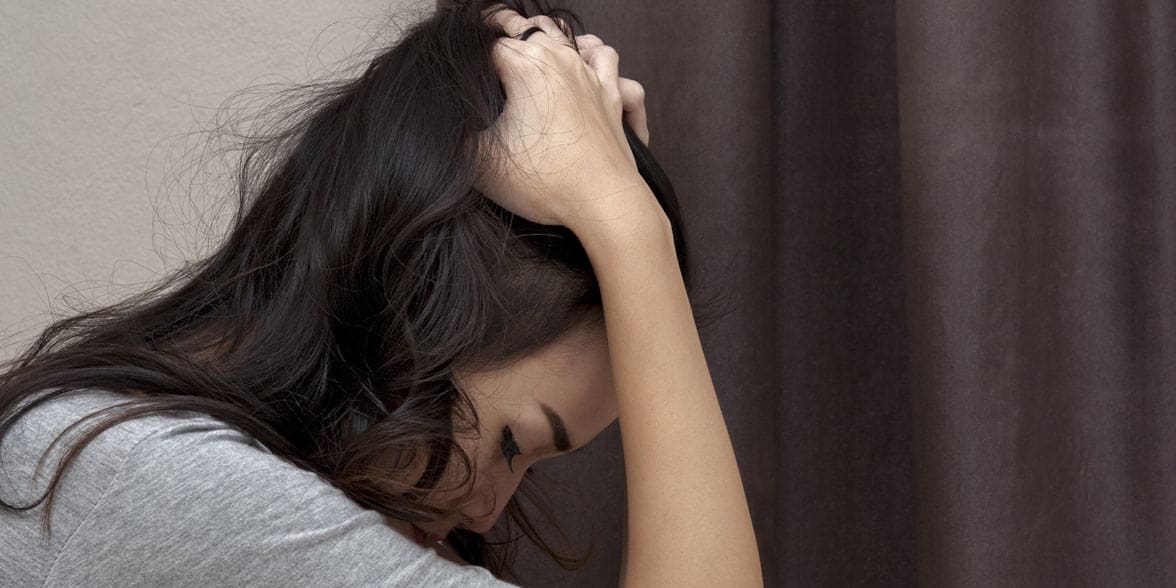 Photo of a woman holding her head