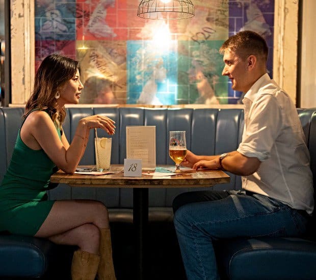 Photo of a young male and female couple sitting in a restaurant on a speed date