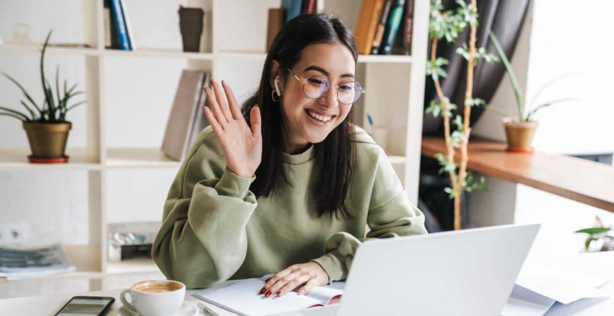 Photo of a woman saying hello on a video call