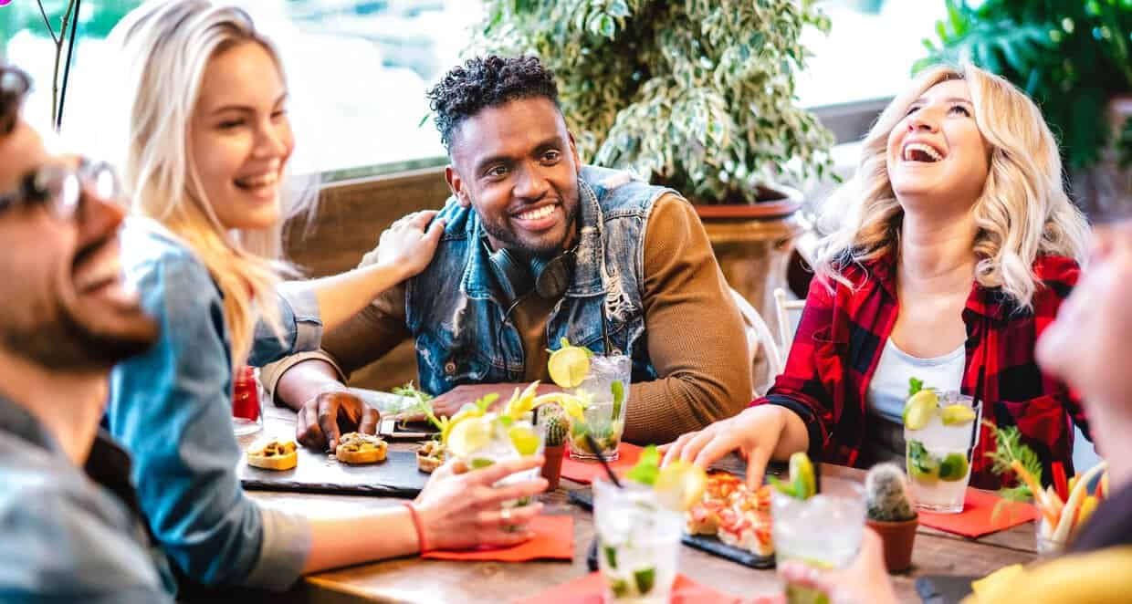 Friends laughing and drinking at table