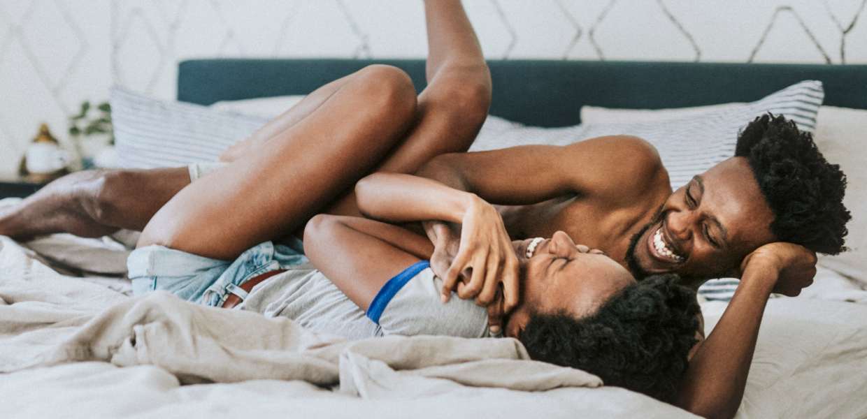 Photo of a couple laughing in bed