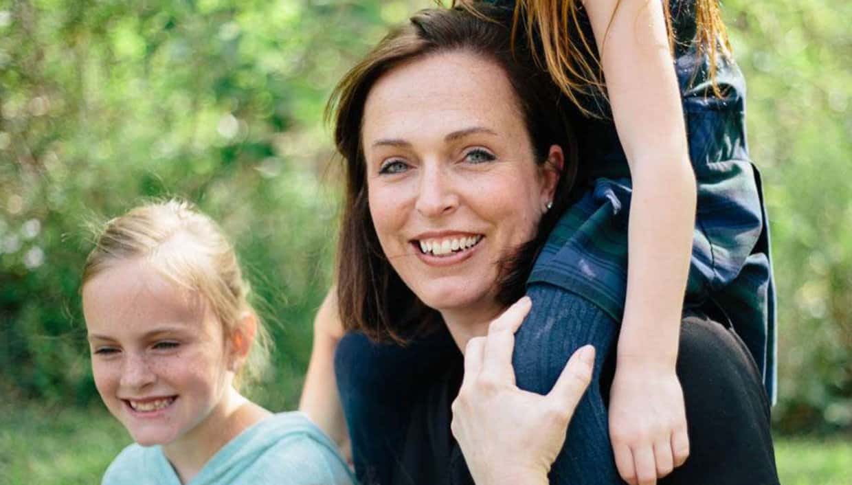 Stock photo of a mom smiling with her two young daughters