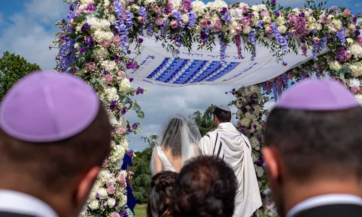 Couple getting married under chuppah
