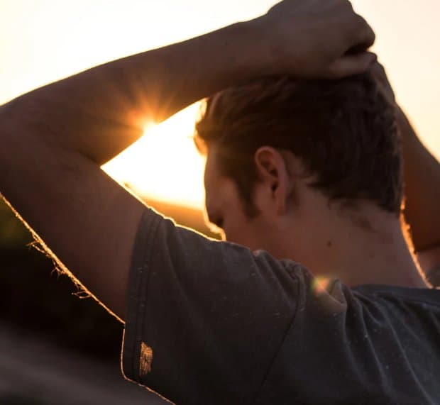 Man holding his hands above his head in thought