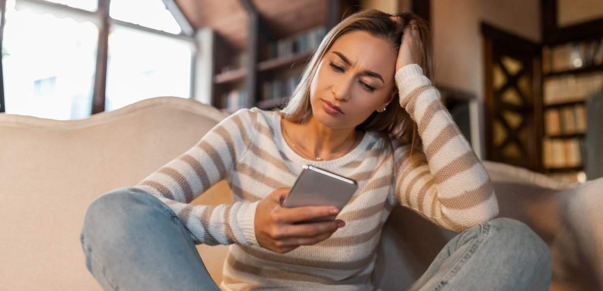 Photo of a woman frowning at her phone