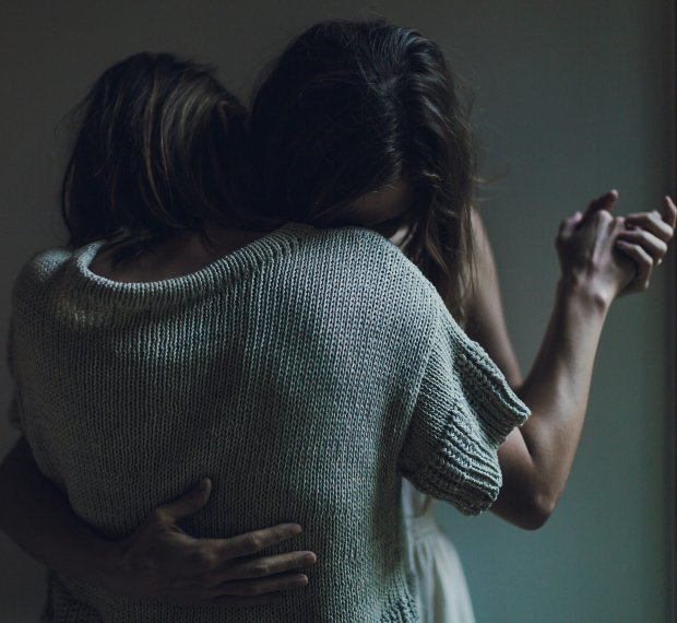 Photo of two women couple hugging and dancing together looking sad and dancing in a dark shadowy room