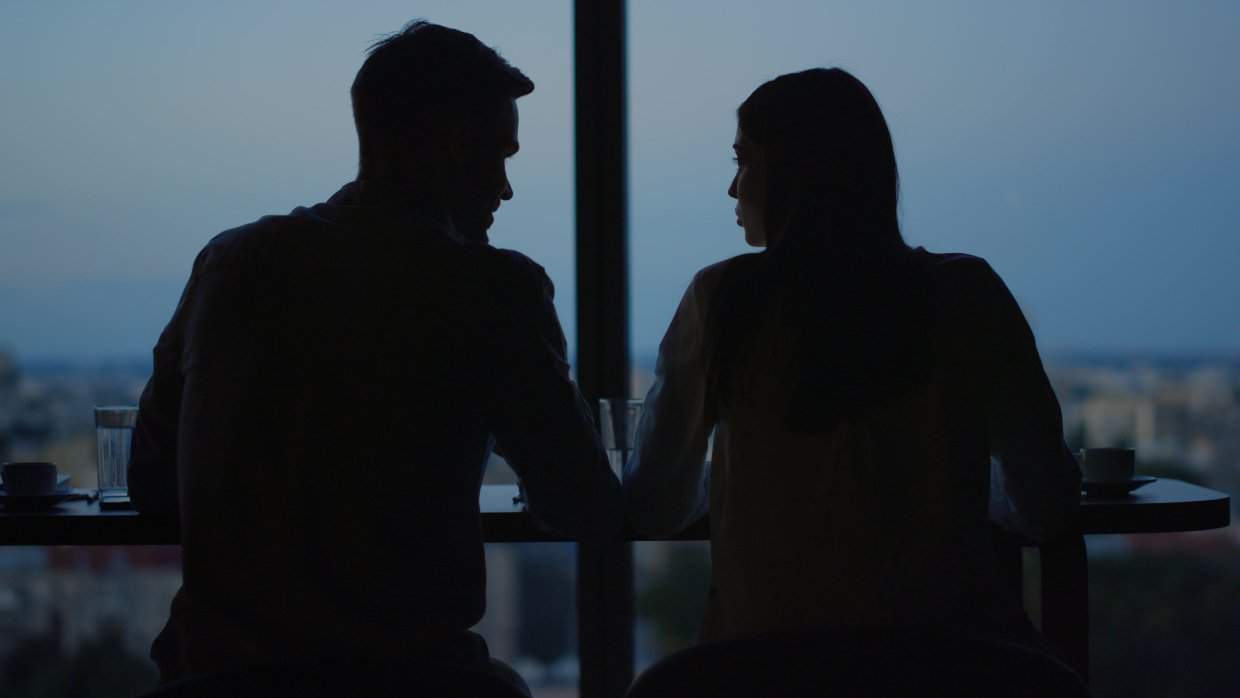 Couple in shadow sitting at table