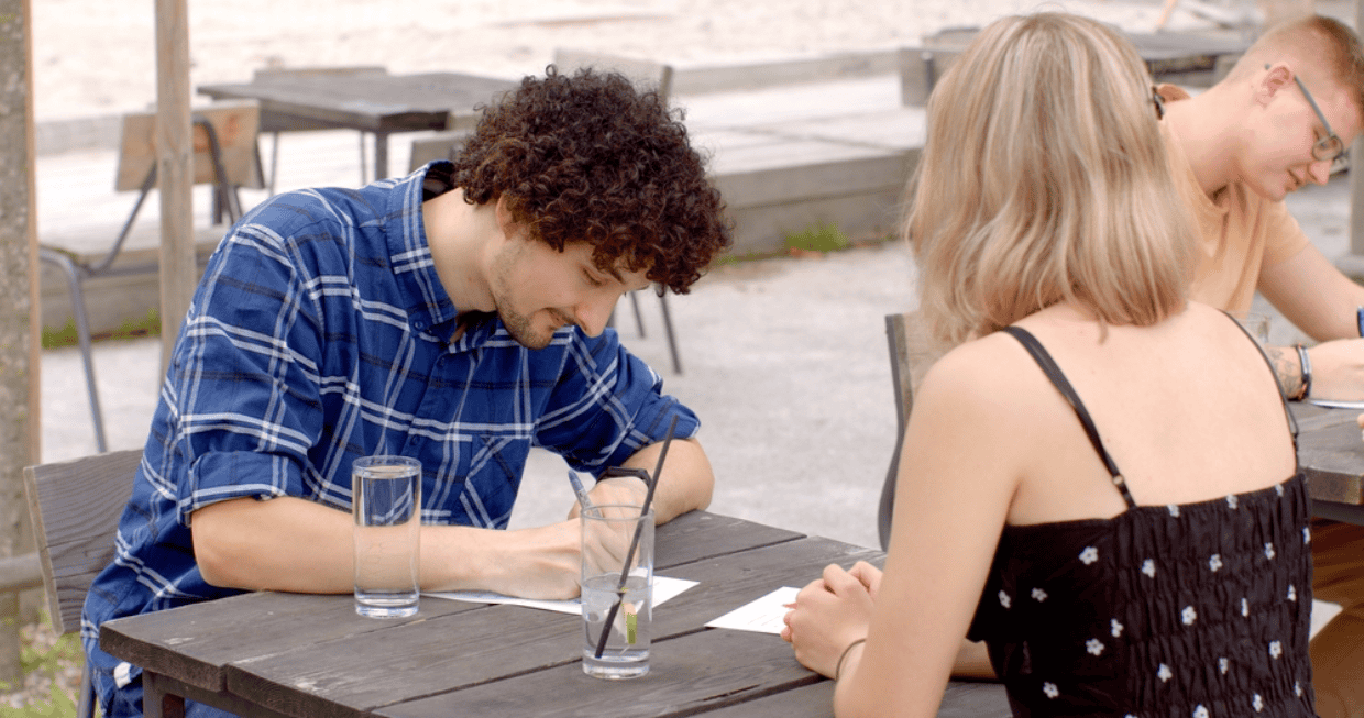 Young man and woman taking notes on speed dating event