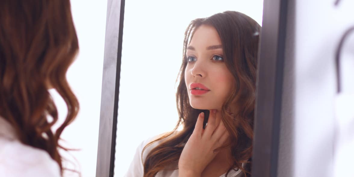 Photo of woman looking in mirror