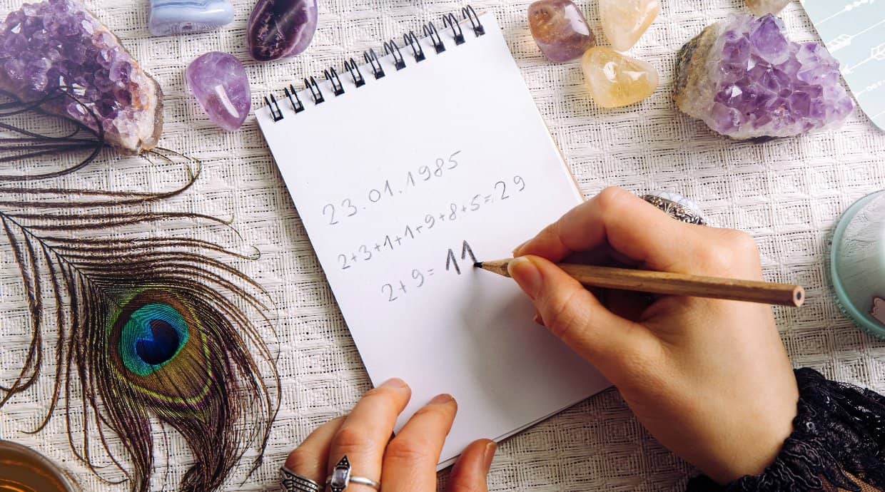Numerology birth date reading on paper surrounded by crystals