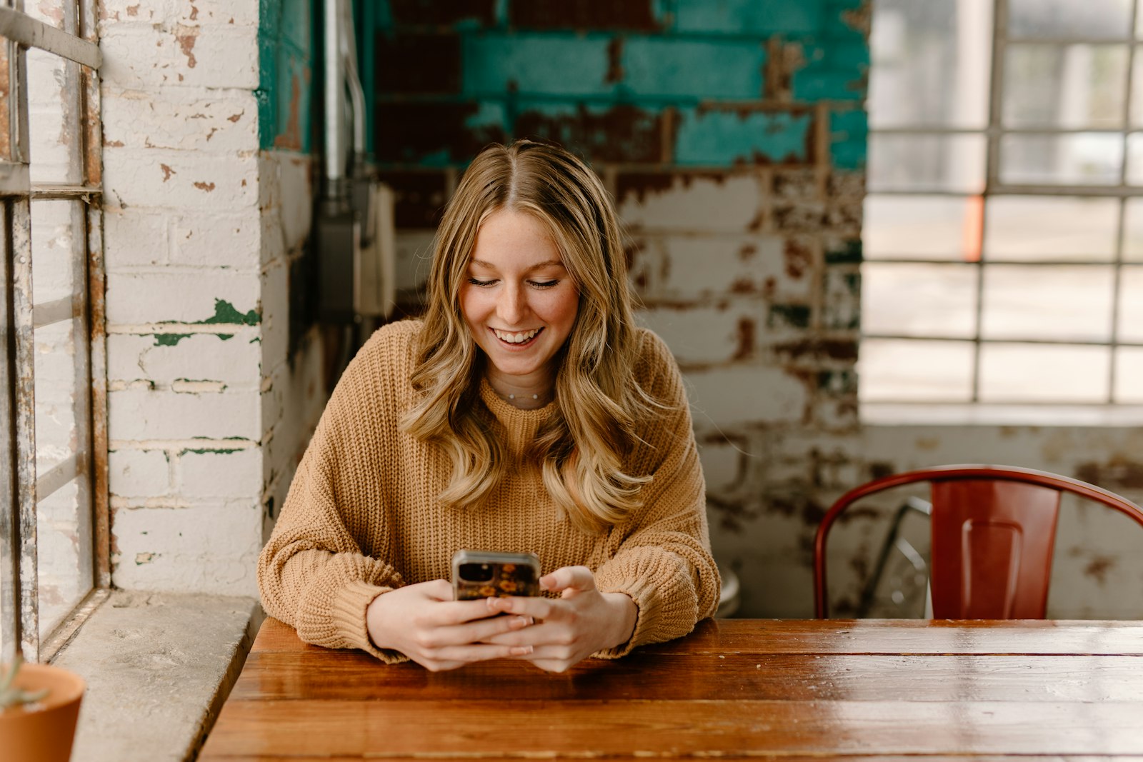 A woman at a table reading something on her phone