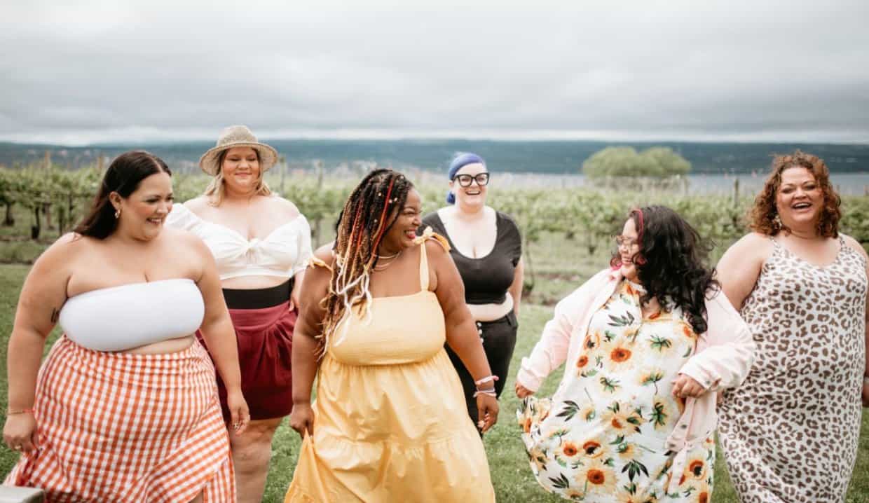 Beautiful curvy women laughing near beach