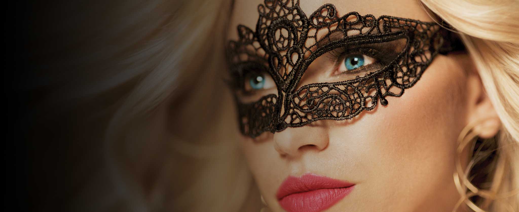 Victoria Milan official homepage photograph: a woman wearing a lace eye mask. A marketing image, not a verified member profile.